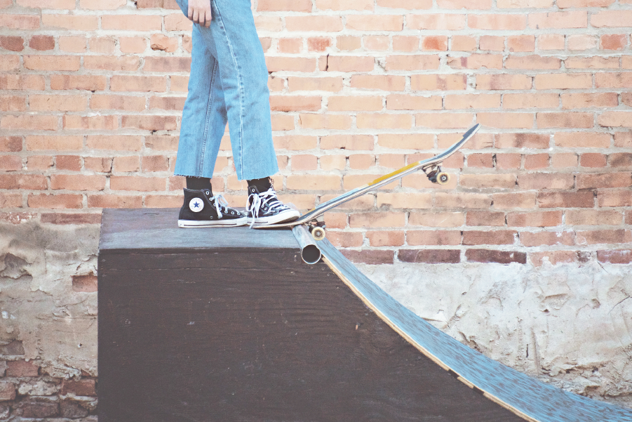 skateboarder about to go down skate ramp.