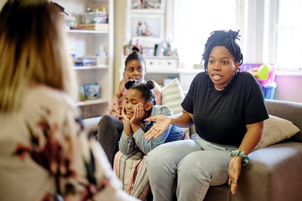 A stressed mother consulting with a provider after being referred to the Triple P (Positive Parenting Program).