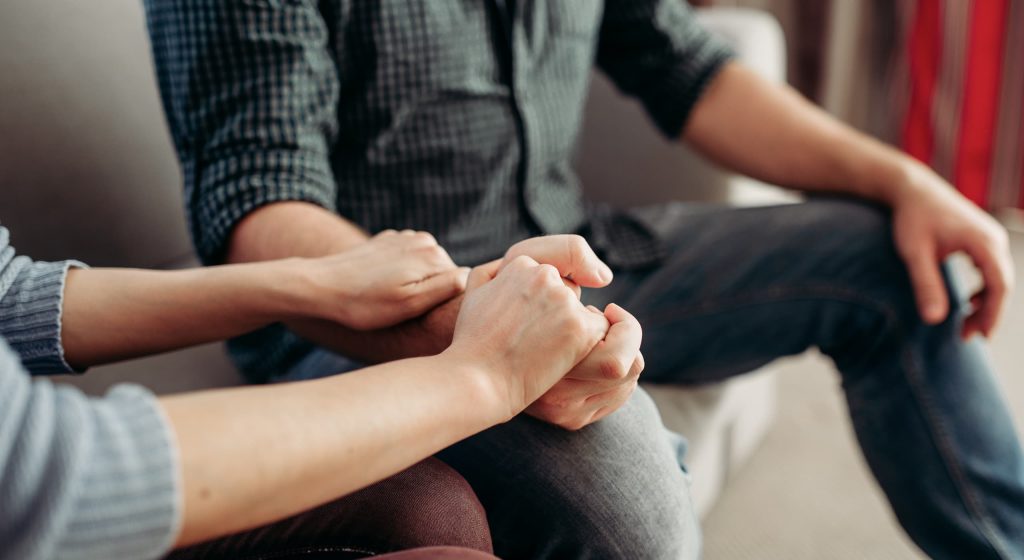 A therapist holding a patient's hand for comfort.